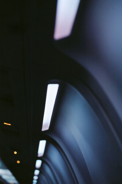 Illuminated row of lights in a darkened tunnel-like space.